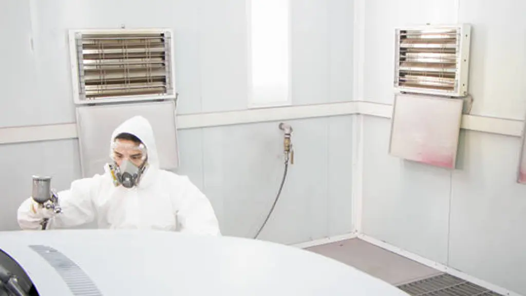 Painter worker holding a spray gun in the paint booth